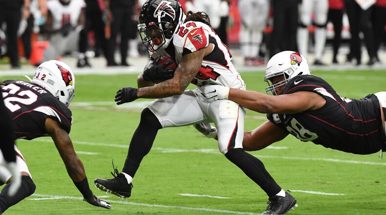 Falcons running back Devonta Freeman attempts to break a tackle by Arizona's Corey Peters during the first half Oct. 13, 2019, at State Farm Stadium in Glendale, Ariz.
