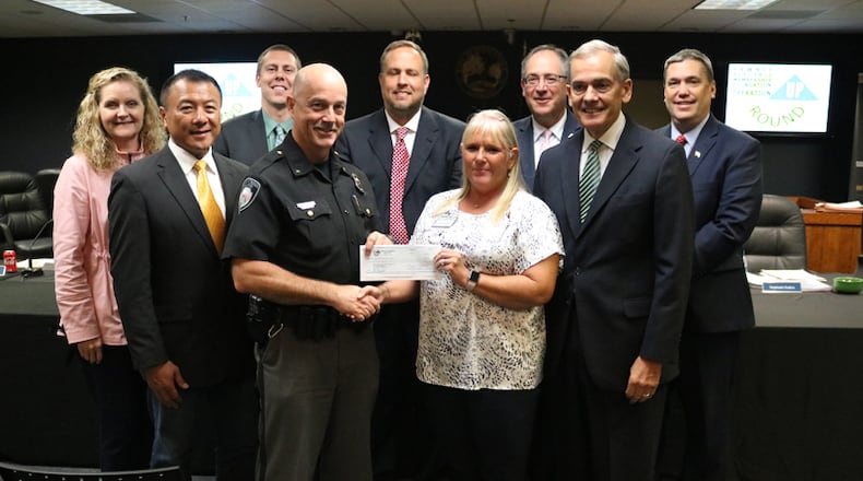 The Sawnee Electric Membership Foundation awards a $7,800 grant to the Johns Creek Public Safety Foundation: (back row) City Council members Stephanie Endres, Jay Lin, Chris Coughlin and John Bradberry; Mayor Mike Bodker; City Council Member Lenny Zaprowski; (front row) Police Chief Ed Densmore; Cindy Badgett, Sawnee EMC; City Council Member Steve Broadbent. CITY OF JOHNS CREEK