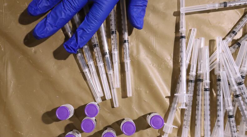 Shown here, an Atlanta nurse-practitioner prepares Pfizer vaccines at a mass vaccination program at Mercedes-Benz Stadium earlier this year. According to documents, the city of Atlanta arranged for some people to get vaccinated at the Mercedes-Benz site who are not yet eligible under state rules. (PHOTO by Curtis Compton / Curtis.Compton@ajc.com)