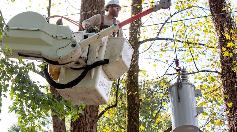 Georgia Power employee Arik Crawford replaces a transformer along West Paces Ferry Road on Friday.