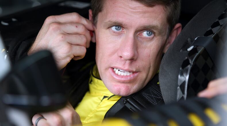 Carl Edwards talks to a crew member before practice for Saturday's NASCAR Sprint Cup series auto race at Charlotte Motor Speedway in Concord, N.C., Friday, Oct. 9, 2015. (AP Photo/Bob Jordan)