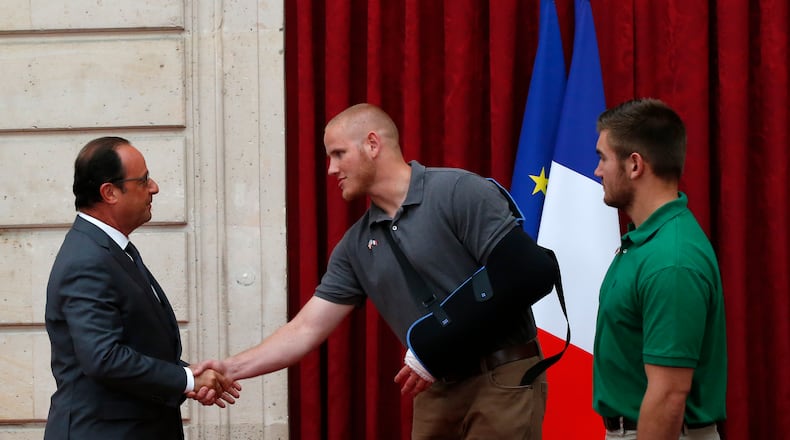 French President Francois Hollande, left, shakes hands with U.S. Airman Spencer Stone, as U.S. National Guardsman from Roseburg, Oregon, Alek Skarlatos, right, looks on at the Elysee Palace on Aug. 24, 2015, in Paris.