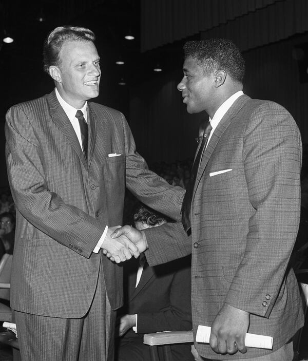 Shaking the hand of heavyweight champion Patterson, who attended one of his prayer meetings in 1961.