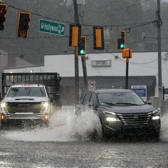 Motorists drive through a flooded street in northwest Atlanta on Saturday, Sept. 12, 2026. (Ben Hendren for the AJC)