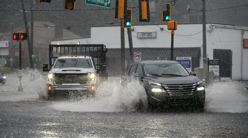 Motorists drive through a flooded street in northwest Atlanta on Saturday, Sept. 12, 2026. (Ben Hendren for the AJC)
