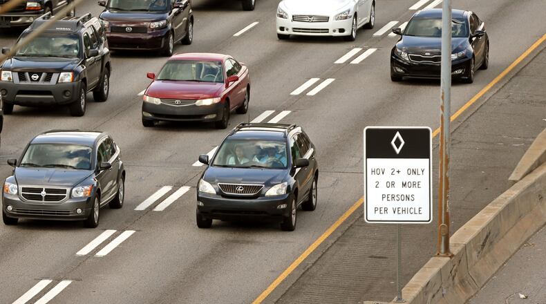 A Lexus SUV travels in the HOV lane as other vehicles are shown in much slower additional lanes on I-85 south approaching the I-75/I-85 connector during rush hour traffic.