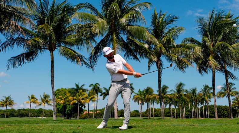 Cameron Young hits along the cart path on the first fairway during the first round of the Cadillac Championship PGA golf tournament Thursday, April 30, 2026, in Doral, Fla. (AP Photo/David J. Phillip)