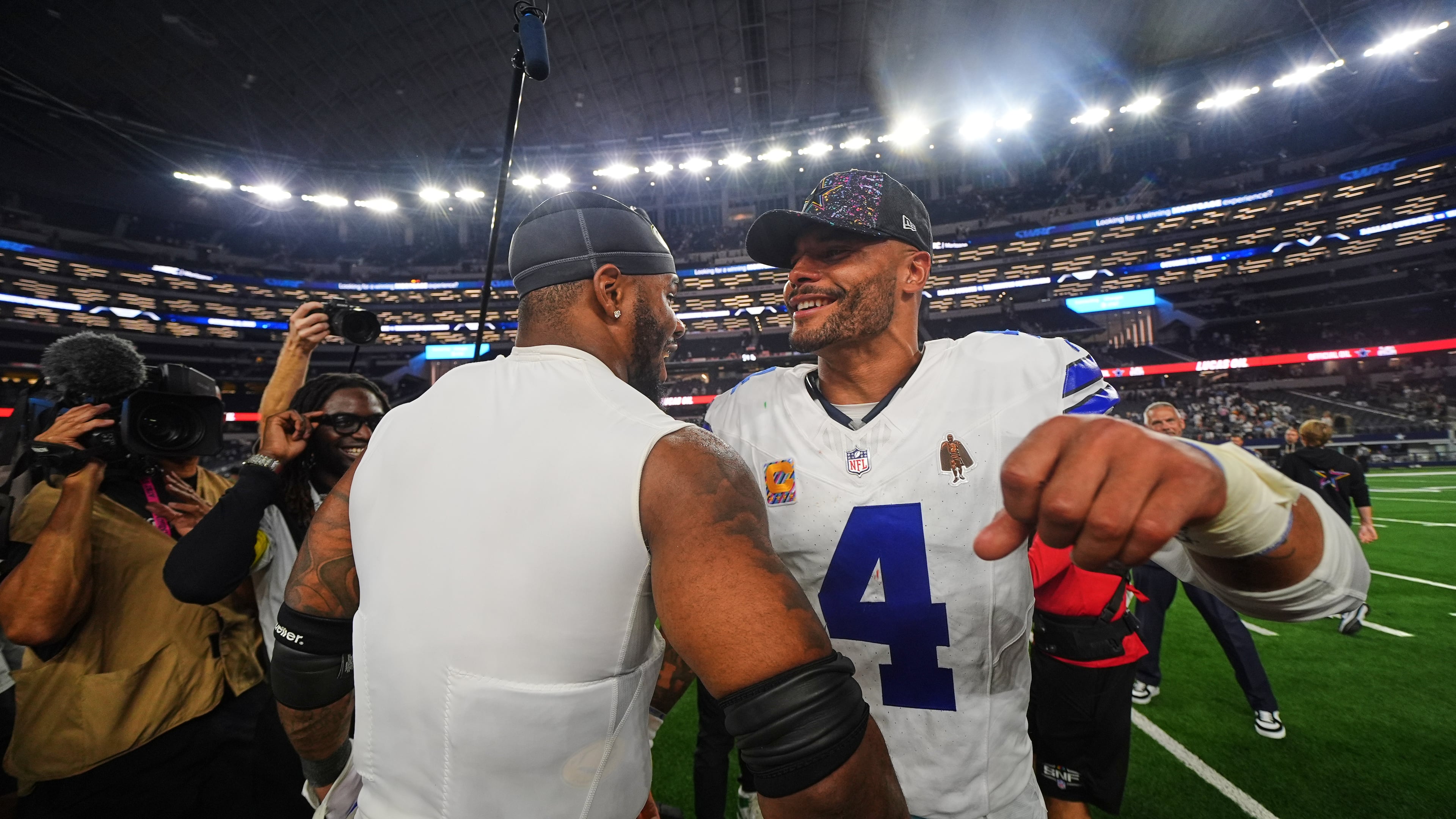 Green Bay Packers defensive end Micah Parsons, left, and Dallas Cowboys quarterback Dak Prescott (4) greet each other after their team's overtime NFL football game which ended in a tie Sunday, Sept. 28, 2025, in Arlington, Texas. (AP Photo/Julio Cortez)