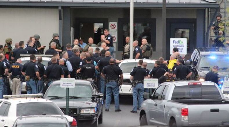 Law enforcement officers gather at the FedEx facility near Kennesaw after Tuesday morning's shootings. John Spink, jspink@ajc.com