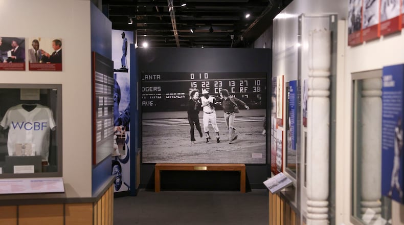 The photograph taken by Ron Sherman shows Hank Aaron greeted by a pair of fans as he rounds the bases following his record-breaking 715th career home run, April 8, 1974, in the exhibit, "Hank Aaron: Chasing The Dream," at the National Baseball Hall of Fame, Thursday, May 23, 2024, in Cooperstown, New York. (Jason Getz/The Atlanta Journal-Constitution/TNS)