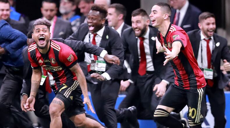 Atlanta United forward Josef Martinez (left) and midfielder Miguel Almiron charge the field to celebrate winning the MLS CUP on Saturday, Dec 8, 2018, in Atlanta. Curtis Compton/ccompton@ajc.com