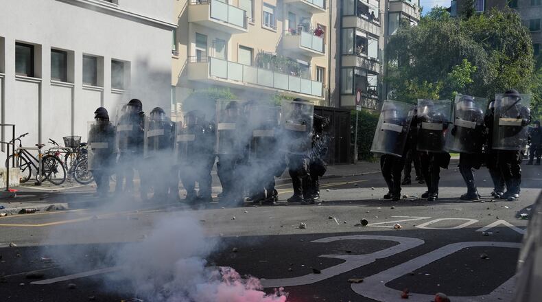 Police form a line in front of a burning flare during a "No G7" demonstration in Geneva, Switzerland, Sunday, June 14, 2026, ahead of the G7 summit scheduled to take place June 15-17. (AP Photo/Baz Ratner)