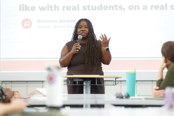 Bolton Academy third grade teacher Breonna Jenkins tells a town hall how she uses technology to help her students read passages and answer questions. Jenkins said it helps prepare them for state tests at the end of the year. (Arvin Temkar/AJC)