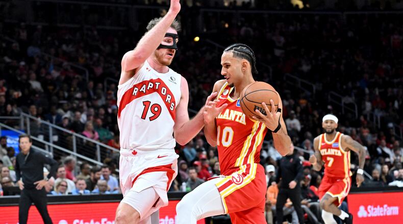 Atlanta Hawks forward Zaccharie Risacher (10) drives against Toronto Raptors center Jakob Poeltl (19) during the second half in the home opener at State Farm Arena, Thursday, October 22, 2025, in Atlanta. Toronto Raptors won 138-118 over Atlanta Hawks. (Hyosub Shin / AJC)