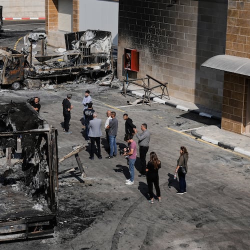 Palestinians and journalists survey damage in an industrial zone following an attack by Israeli settlers the previous day in the West Bank village of Beit Lid, near Tulkarm, Wednesday, Nov. 12, 2025. (AP Photo/Majdi Mohammed)