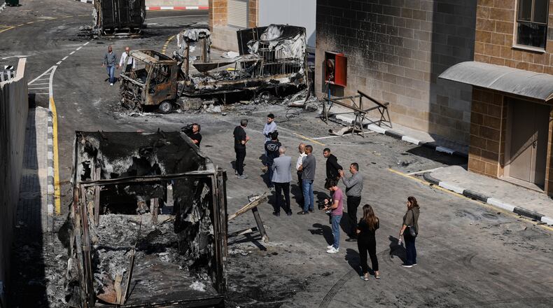 Palestinians and journalists survey damage in an industrial zone following an attack by Israeli settlers the previous day in the West Bank village of Beit Lid, near Tulkarm, Wednesday, Nov. 12, 2025. (AP Photo/Majdi Mohammed)