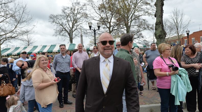 In this March 2014 file photo, sculptor Andy Davis walks back to his seat after being greeted by guests before his Patrick Henry sculpture was dedicated in downtown McDonough. HYOSUB SHIN / HSHIN@AJC.COM
