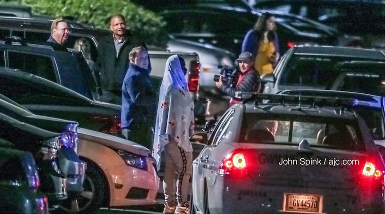 Residents wait in the parking lot of the Park at Peachtree Corners Apartments on Thursday morning while Gwinnett County police investigate a homicide. JOHN SPINK / JSPINK@AJC.COM