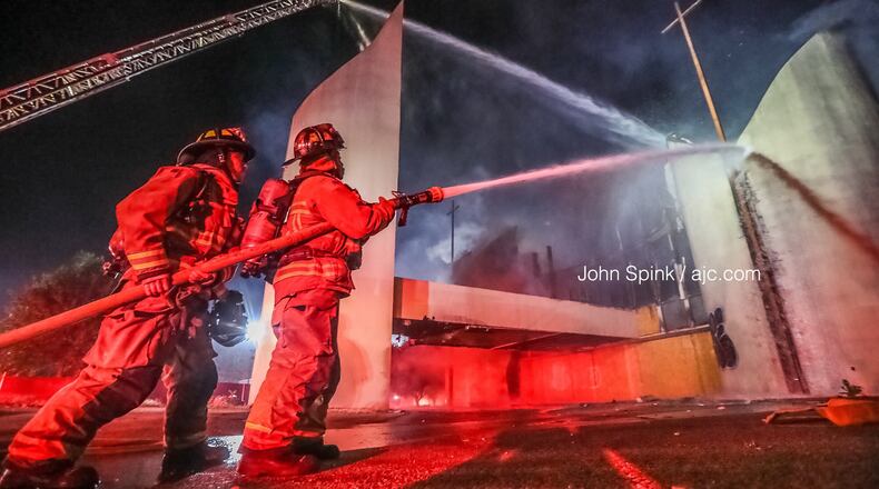 Alanta fire crews douse the blaze Friday morning at an abandoned church building on Clifton Street near Alonzo A. Crim Open Campus High School.