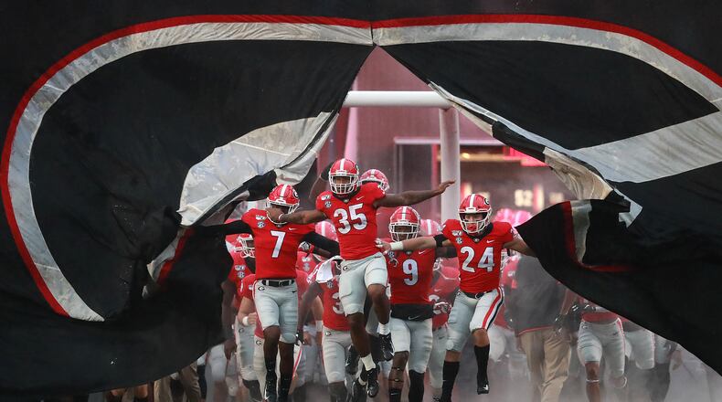 Georgia players break through the giant banner while taking the field. Curtis Compton/ccompton@ajc.com