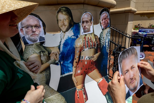 Activists put photos of (L-R) Office of Management and Budget director Russell Vought, White House deputy chief of staff Stephen Miller, and Secretary of Health and Human Services Robert F. Kennedy Jr. on a cutout of ABBA at a demonstration protesting President Donald Trump’s proposed cuts to health services outside the Centers for Disease Control and Prevention (CDC) headquarters in Atlanta on Tuesday, June 10, 2025. (Arvin Temkar/AJC)