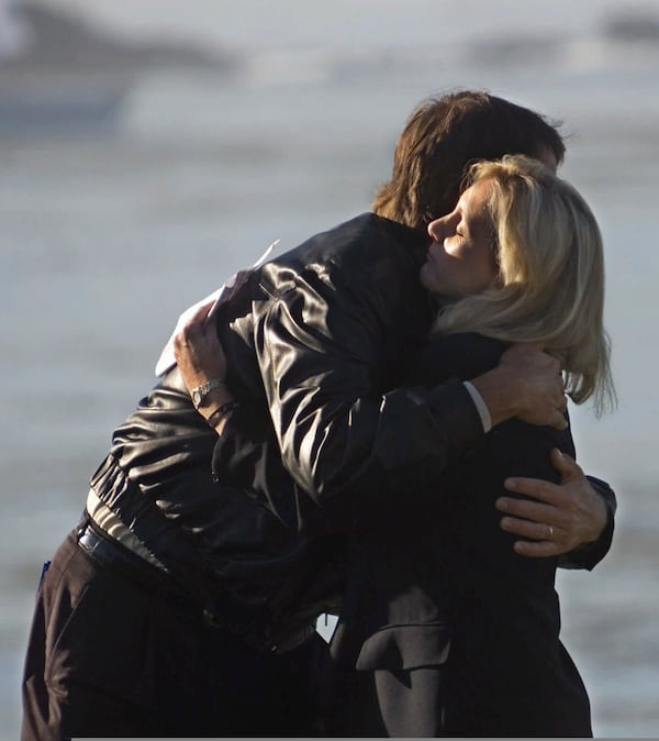FILE - Paul Azinger gives Tracey Stewart a hug during a ceremony on the 18th hole at Pebble Beach, in memory of her husband Payne Stewart, during a practice day for the 100th U.S. Open in Pebble Beach, Calif., Wednesday, June 14, 2000. (AP Photo/Eric Risberg, file)