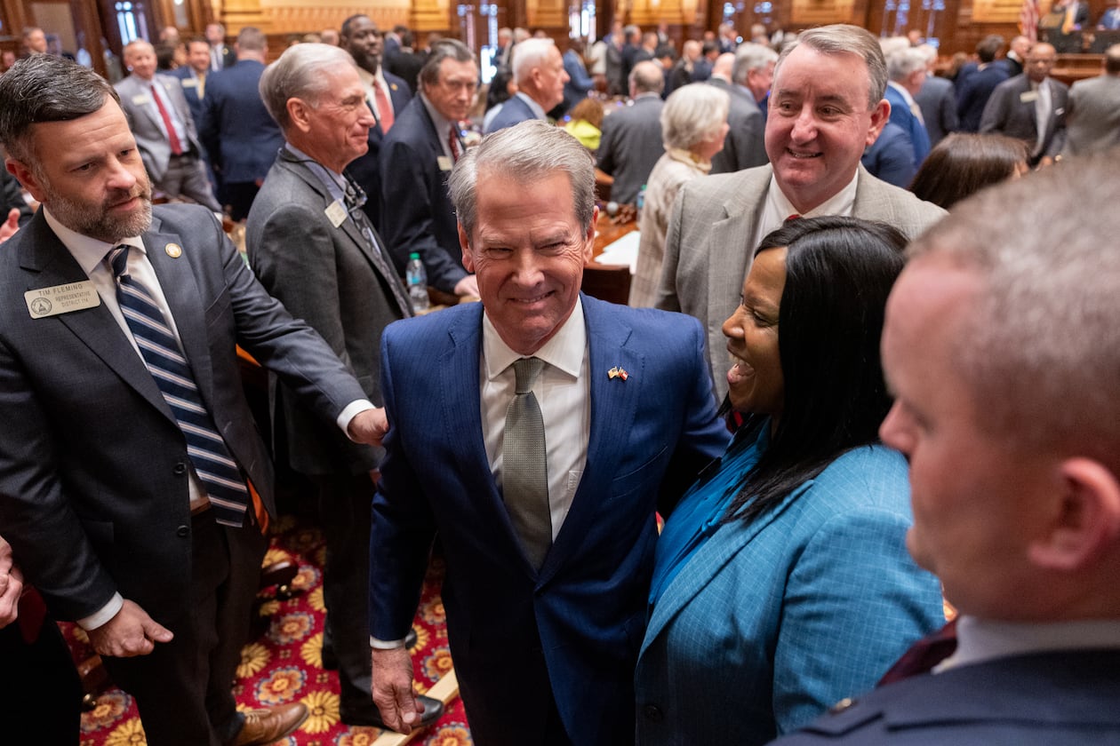 Gov. Brian Kemp (center) leaves his final State of the State address before lawmakers at the Capitol in Atlanta on Thursday. (Arvin Temkar/AJC)