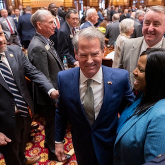Gov. Brian Kemp (center) leaves his final State of the State address before lawmakers at the Capitol in Atlanta on Thursday. (Arvin Temkar/AJC)