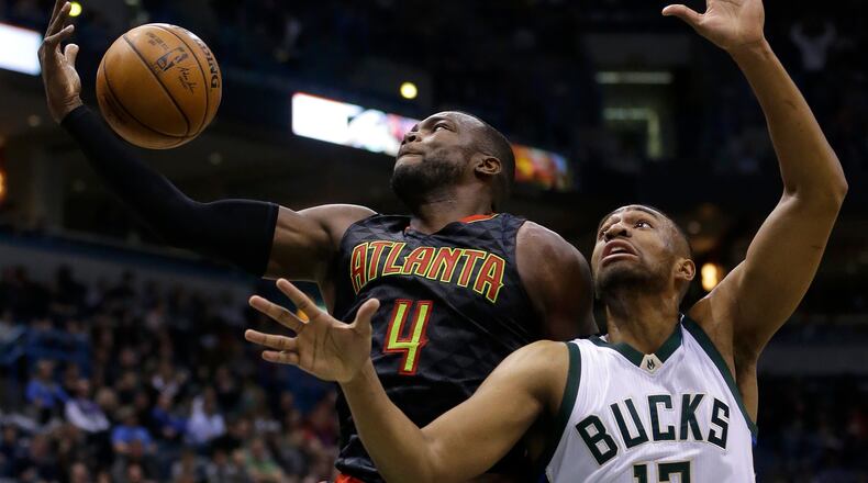 Atlanta Hawks’ Paul Millsap (4) catches a pass over Milwaukee Bucks’ Jabari Parker (12) during the second half of an NBA basketball game Friday, Dec. 9, 2016, in Milwaukee. The Hawks won 114-110. (AP Photo/Aaron Gash)