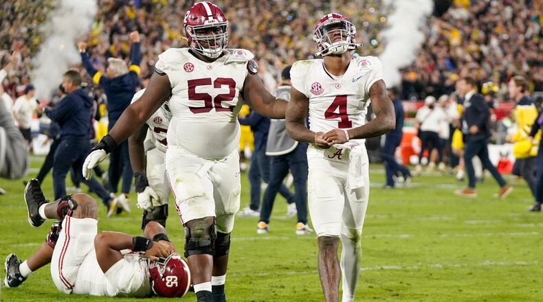 Alabama quarterback Jalen Milroe (4) and offensive lineman Tyler Booker (52) walk off the field after a loss to Michigan in the Rose Bowl CFP NCAA semifinal college football game Monday, Jan. 1, 2024, in Pasadena, Calif. (AP Photo/Mark J. Terrill)