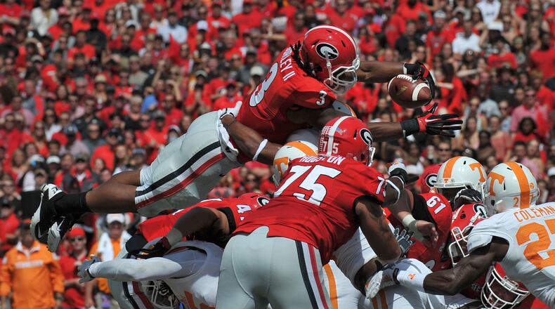 Geprgia Bulldogs running back Todd Gurley leaps over a pile of Tennessee defenders for a second quarter touchdown at Sanford Stadium Saturday September 27, 2014. BRANT SANDERLIN / BSANDERLIN@AJC.COM