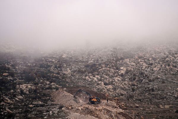FILE - An Israeli bulldozer maneuvers on the buffer zone near the so-called Alpha Line that separates the Israeli-controlled Golan Heights from Syria, viewed from the town of Majdal Shams, Dec. 21, 2024. (AP Photo/Matias Delacroix, File)