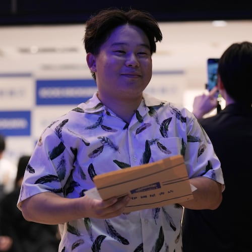 Atsushi Watanabe, a college student from Hadano, southwest of Tokyo, receives a copy of Haruki Murakami's new book titled "The Tale of KAHO" minutes after the clock struck midnight during a countdown event at a Kinokuniya bookstore in Tokyo, Friday, July 3, 2026. (AP Photo/Hiro Komae)