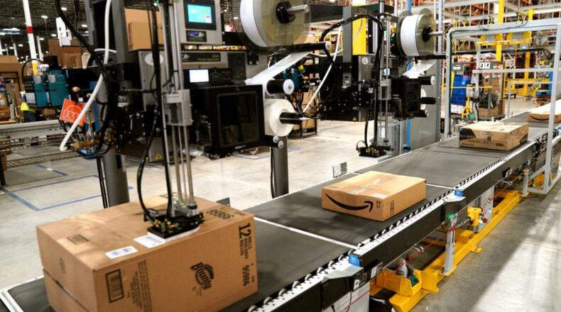 A machine applies shipping lables to packed orders at an Amazon fulfillment center.
