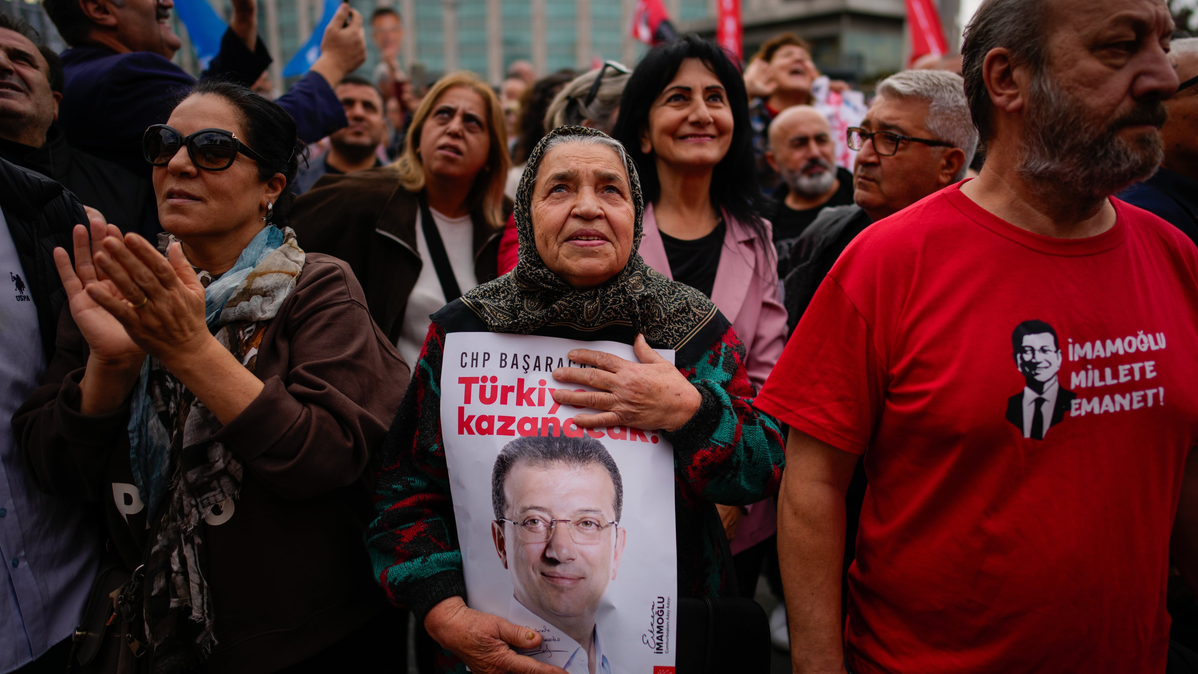 People listen to speeches during a rally in support of Istanbul's imprisoned opposition Mayor Ekrem Imamoglu as he appears for a hearing at the Caglayan courthouse, in Istanbul, Turkey, Sunday, Oct. 26, 2025. The poster with the photo of Imamoglu reads in Turkish: "Turkey will win". (AP Photo/Emrah Gurel)