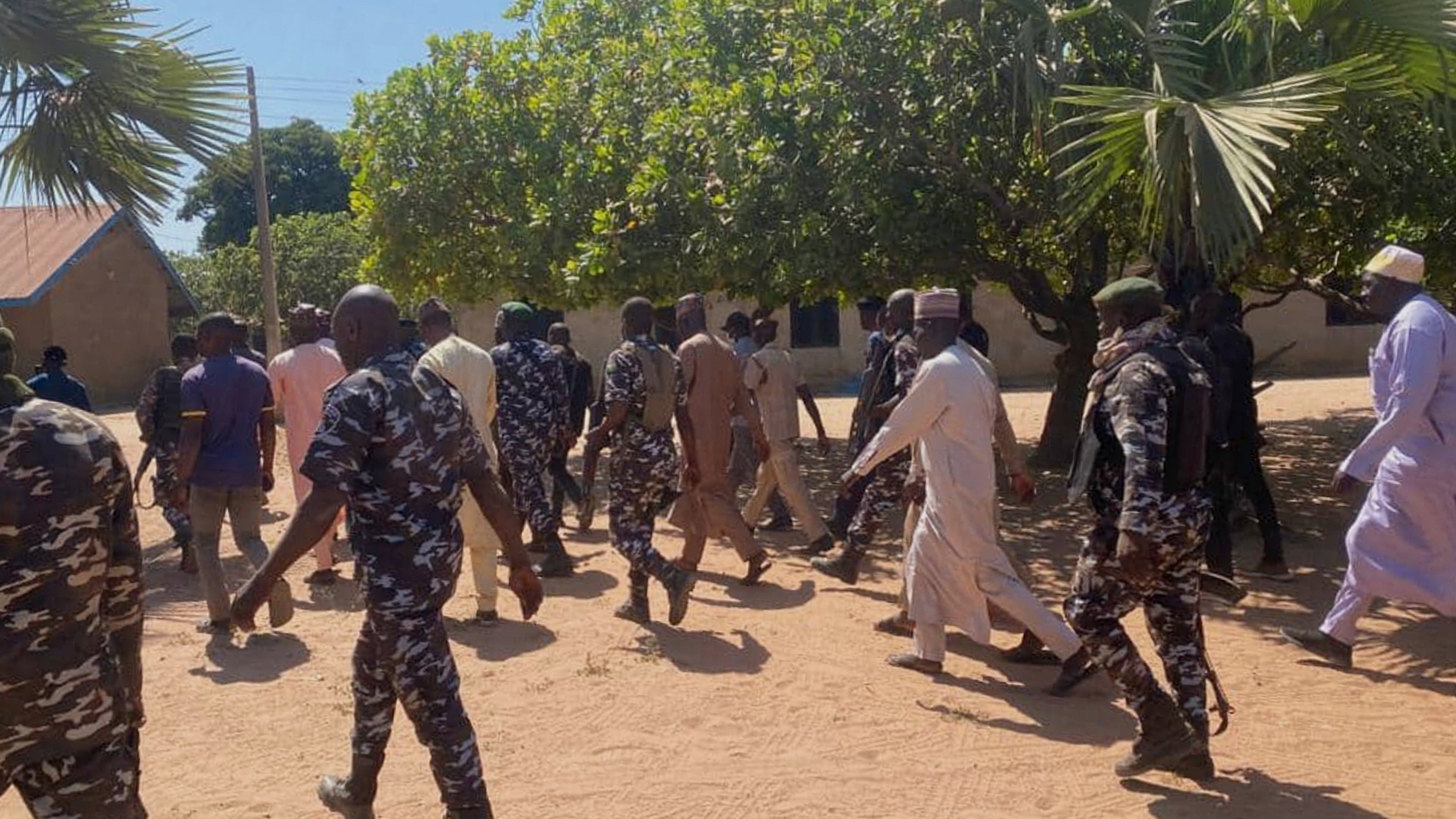 Police and government officials walk past St. Mary's Catholic Primary and Secondary School where gunmen on Friday abducted children and staff in Papiri community, Nigeria, Tuesday, Nov.25, 2025. (AP Photo/Yunusa Umar )