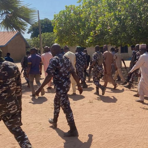 Police and government officials walk past St. Mary's Catholic Primary and Secondary School where gunmen on Friday abducted children and staff in Papiri community, Nigeria, Tuesday, Nov.25, 2025. (AP Photo/Yunusa Umar )