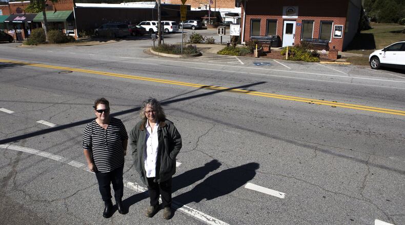 10-24-18 - Statham, GA - Catherine Corkren (left), 47, of Atlanta, Ga., and Sondra Moore, 47, of Hoschton, Ga., pose for a portrait across the road from Statham City Hall in Statham, Ga., on Wednesday, Oct. 24, 2018. Because of open criticism due to what they say is wrongdoing by the city, both Corkren and Moore have been banned from the city of Statham. According to Corkren, they are not allowed on any city property, including sidewalks, which is why Corkren and Moore had to stand across the street and beside the road during this portrait. (Casey Sykes for The Atlanta Journal-Constitution)