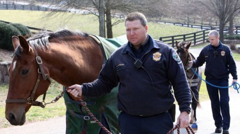 Milton firefighter Shane Black (left) walks Ali as Alex Fortner handles Toy.