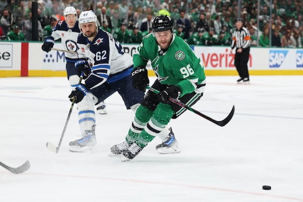 Dallas Stars right wing Mikko Rantanen (96) and Winnipeg Jets right wing Nino Niederreiter (62) compete for control of the puck in the first period of Game 4 of a second-round NHL hockey playoff series in Dallas, Tuesday, May 13, 2025. (AP Photo/Gareth Patterson)
