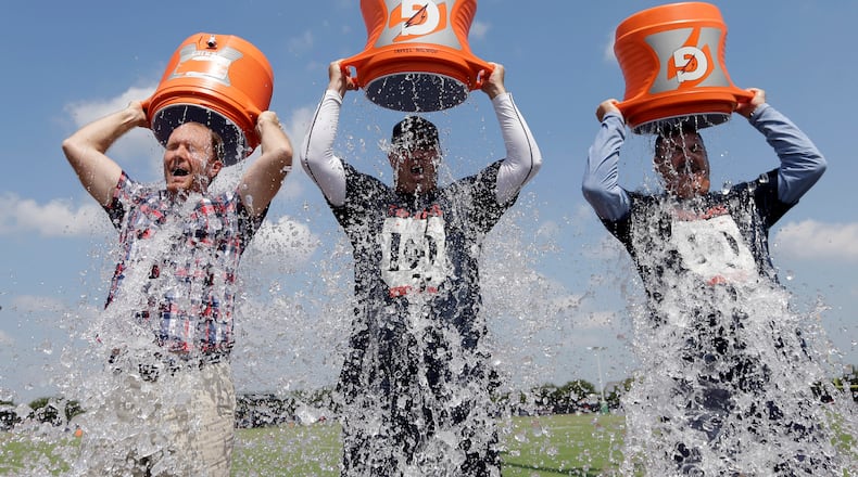 In 2014, a wave of social media users, athletes and notable figures -- including Bill O’Brien, center, then the coach of the Houston Texans -- joined the ice bucket challenge. Participants in the viral campaign raised money to fight ALS and drew attention to the cause by pouring buckets of ice water over their heads and posting the videos online. The challenge has made a comeback in 2025 for a new cause. (AP file photo/David J. Phillip)