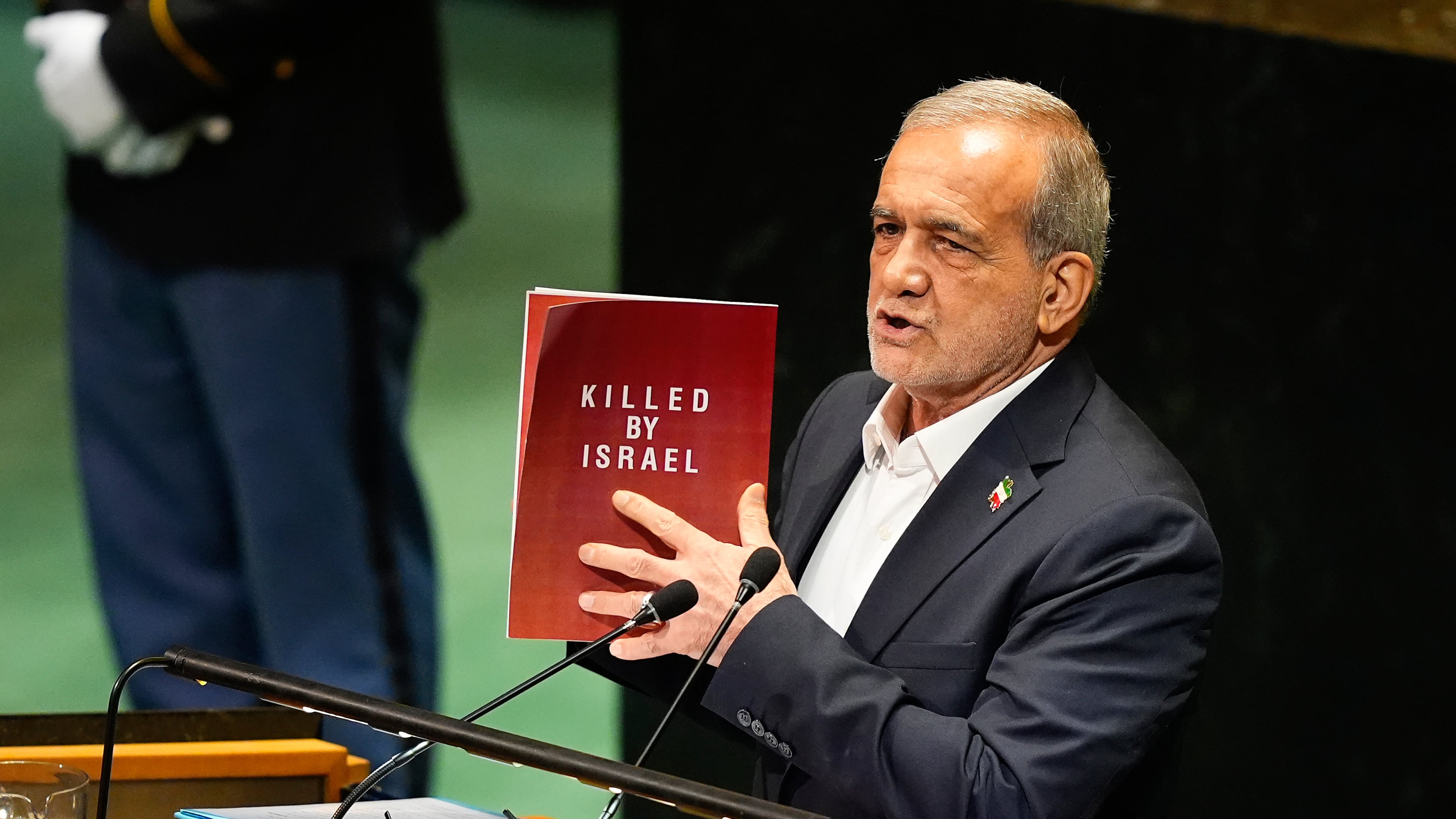 Iran President Masoud Pezeshkian holds up a book while speaking during the 80th session of the United Nations General Assembly, Wednesday, Sept. 24, 2025, at U.N. headquarters. (AP Photo/Yuki Iwamura)