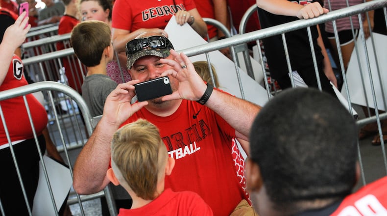 Georgia running back Nick Chubb (27) takes a picture with a young fan at UGA UGA Picture Day. Chubb is a Heisman Trophy contender heading into the 2015 season, and a fan favorite.