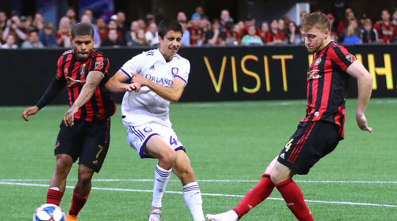 Atlanta United midfielder Julian Gressel scores an apparent goal past Orlando City defender Joao Moutinho with Josef Martinez looking on during the second half in a MLS soccer match on Sunday, May 12, 2019, in Atlanta. The goal was taken off the board after review, but Atlanta United held on to win the game 1-0. Curtis Compton/ccompton@ajc.com