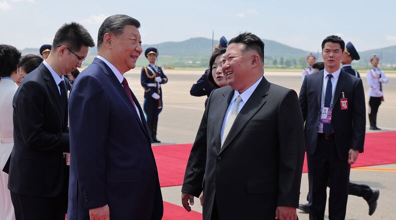 In this photo provided by the North Korean government, North Korean leader Kim Jong Un, front right, greets Chinese President Xi Jinping, center left, on the latter's arrival at the airport in Pyongyang, Monday, June 8, 2026. Independent journalists were not given access to cover the event depicted in this image distributed by the North Korean government. The content of this image is as provided and cannot be independently verified. Korean language watermark on image as provided by source reads: "KCNA" which is the abbreviation for Korean Central News Agency. (Korean Central News Agency/Korea News Service via AP)