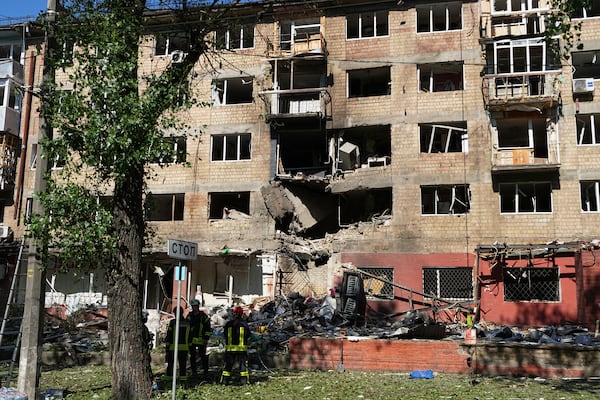 Firefighters work at a destroyed apartment building after a Russian drone and missile attacks in Kyiv, Ukraine, Friday, July 4, 2025. (AP Photo/Efrem Lukatsky)