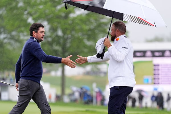 Keegan Bradley, left, and Shane Lowry, of Ireland, shake hands after the second round of the Truist Championship golf tournament at the Philadelphia Cricket Club, Friday, May 9, 2025, in Flourtown. (AP Photo/Matt Rourke)