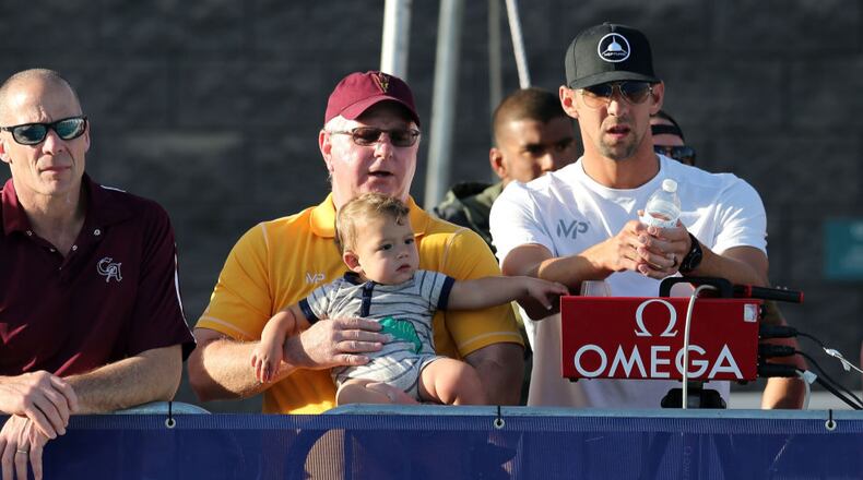 Coach Bob Bowman, Michael Phelps and his son Boomer watch the finals of the men's 400-meter individual medley during last month's Arena Pro Swim Series in Mesa, Arizona.