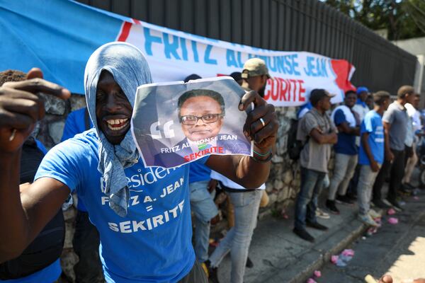 Supporters celebrate the installation of Fritz Alphonse Jean, an economist and former central bank governor, who replaces Leslie Voltaire in the rotating presidency of the transitional presidential council, in Port-au-Prince, Haiti, Friday, March 7, 2025. (AP Photo/Odelyn Joseph)