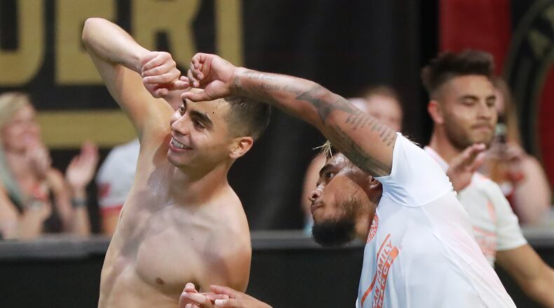 Atlanta United midfielder Miguel Almiron (left) celebrates his goal against Columbus Crew with Josef Martinez for a 3-1 victory during the second half in a MLS soccer match on Sunday, August 19, 2018, in Atlanta. Martinez had an assist on the goal and also tied the MLS season scoring record with his 27th goal during the first half.  Curtis Compton/ccompton@ajc.com